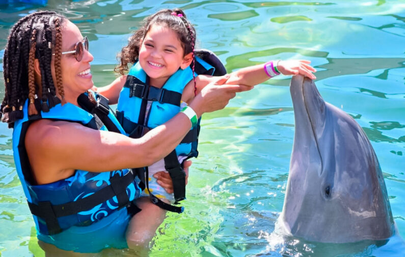 mom and girl swimming with dolphins in dolphin cove jamaica